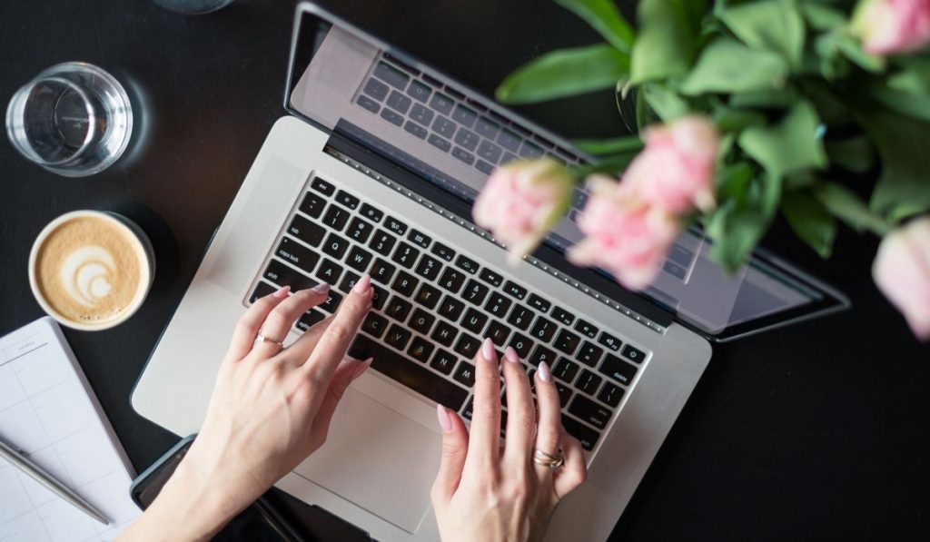 a woman typing on the laptop